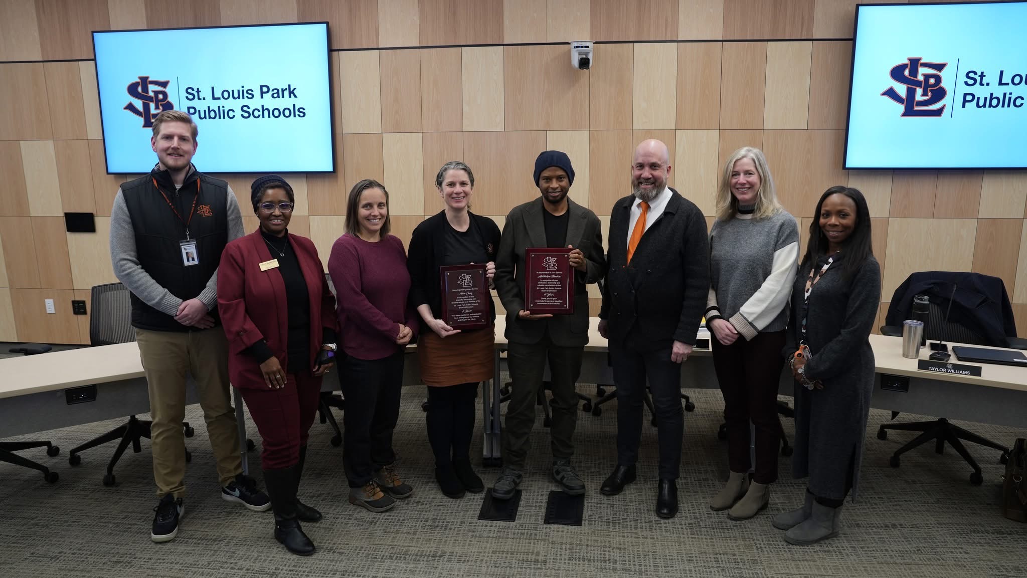 Abdihakim with fellow school board members holding service plaques